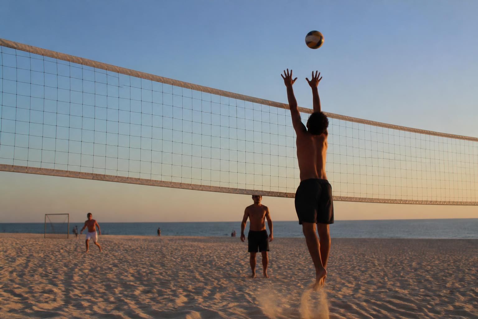 Bloqueador de costas com as mãos acima da rede de vôlei de praia, bola no ar e luz de fim de tarde